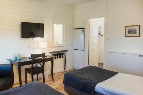 Habitación pequeña con escritorio, cama y cocina. en Sjögestad Motell, en Vikingstad