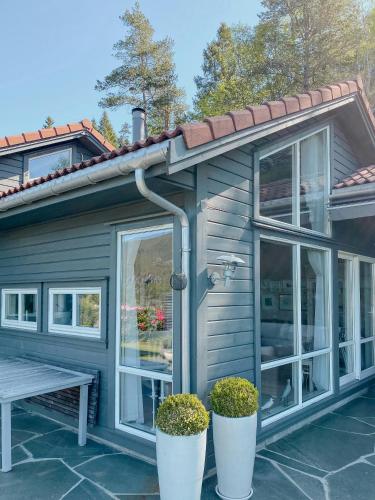 a house with windows and plants in front of it at Cozy Cabin With Økstrafjord View in Jelsa