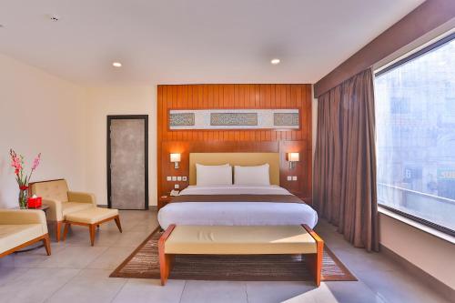 a bedroom with a bed and a large window at Avari Boutique Gujranwala in Fattu Mand