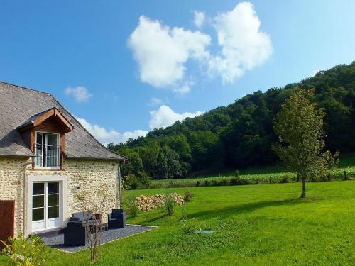 une maison en pierre dans un champ herbeux avec une montagne dans l'établissement Gite-Holiday Home Au Moulin 1771, à Monein
