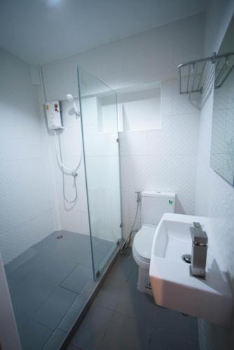 a bathroom with a shower and a toilet and a sink at Urban Hostel Bangkok in Bangkok
