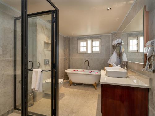 a bathroom with a tub and a toilet and a sink at Faiz Resort Pahalgam in Pahalgām