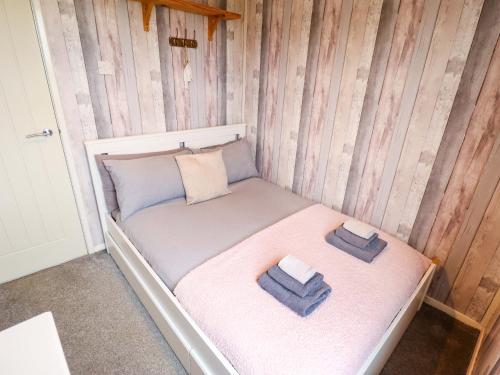a small bed in a room with two pillows on it at Moggs Retreat in Skegness
