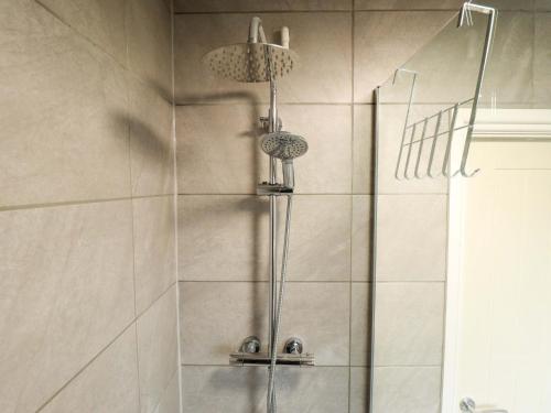 a bathroom with a shower with two shower heads at Moggs Retreat in Skegness