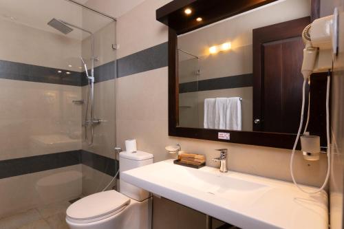 a bathroom with a sink and a toilet and a mirror at Oak Ray City Hotel in Kandy