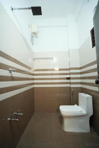 a bathroom with a white toilet and a shower at EK Residency in Anaviratty