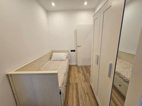 a small room with two beds and a closet at Apartamento Plaza de Armas 2 in Ferrol