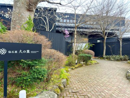a sign in front of a building with a brick walkway at Sengokuhara Hisanoha in Hakone