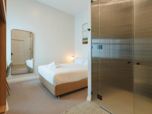 a bedroom with a bed and a mirror and a shower at Commercial Hotel Boonah in Boonah