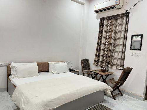 a bedroom with a bed and a table and chairs at Ligree Hotel and Restaurant in Jatwāra