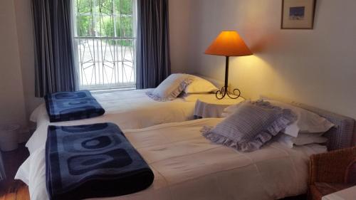 two twin beds in a room with a window at Little Green World in Beaufort West