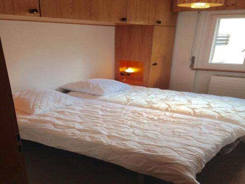 a bedroom with a large white bed with a window at Apartment in Veysonnaz near Ski Gondola in Veysonnaz