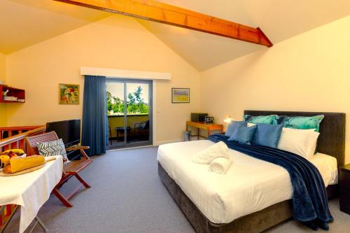 a bedroom with a large bed with blue pillows at Tranquil Vale Vineyard in Luskintyre
