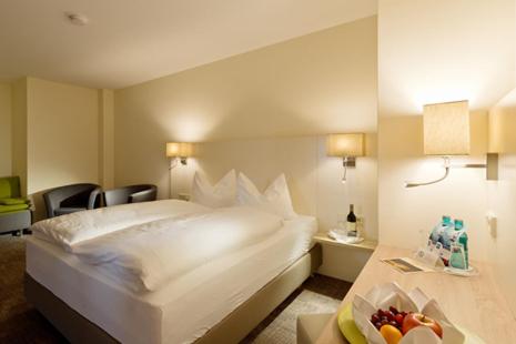 ein Hotelzimmer mit einem Bett und einer Obstschale in der Unterkunft Hotel-Restaurant Krüger in Grafhorst