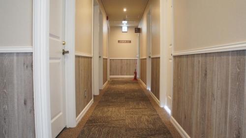 a long hallway with wood paneled walls and a hallway with a hallway at HOTEL THE CUBE Naha Kokusai Street in Naha