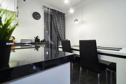 a dining room with a glass table and black chairs at Apartament Perła Pienin in Dębno