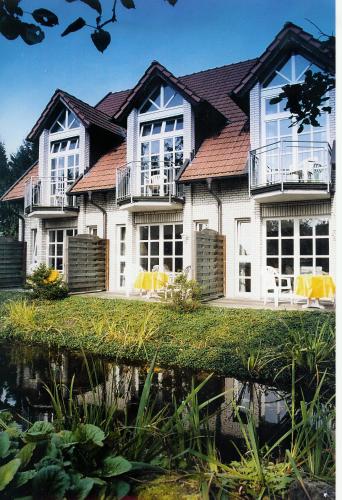 a large house with yellow chairs in front of it at Hotel Hubertushof in Ibbenbüren