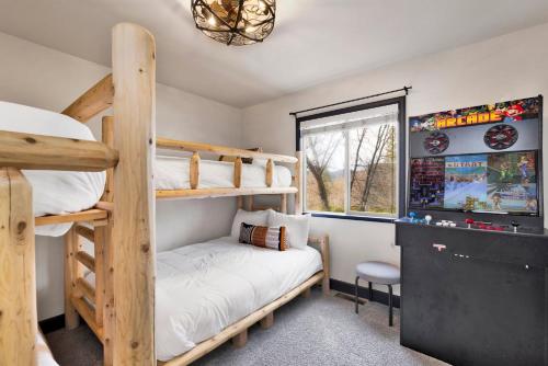 a bedroom with two bunk beds and a television at 2614 - Cielos Nest in Big Bear Lake