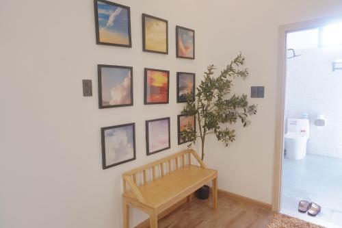 a room with a bench and pictures on a wall at Hyn's House in Danang