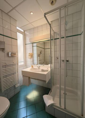 un bagno con lavandino, doccia e WC di Hôtel Foch a Lione