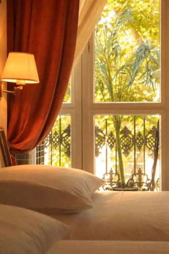 una camera da letto con un letto e una grande finestra di Hôtel Foch a Lione