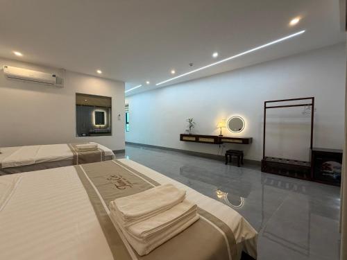 two beds in a room with a mirror and a tv at Honeybee Villa in Văn Lâm