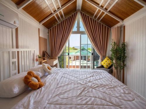a bedroom with a bed with two teddy bears on it at Peace poolvilla sattahip พีซ พลูวิลล่า สัตหีบ in Ban Tao Than