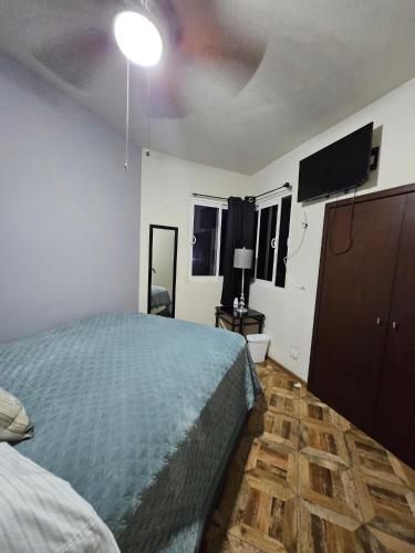 a bedroom with a bed and a flat screen tv at Villas Serena Rosarito in Rosarito Beach