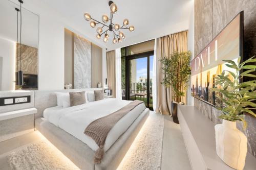 a bedroom with a large bed and a chandelier at DVH Luxe, Elegant 4BR Villa, Gated Resort Amenities, Ranches 3 in Dubai