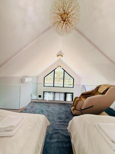 a room with two beds and a chandelier at Panoramic House Baile Felix C2 in Baile Felix