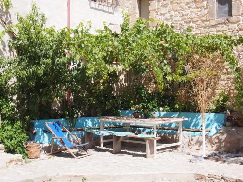 a picnic table and a blue bench and trees at Vinciucci in Ispica