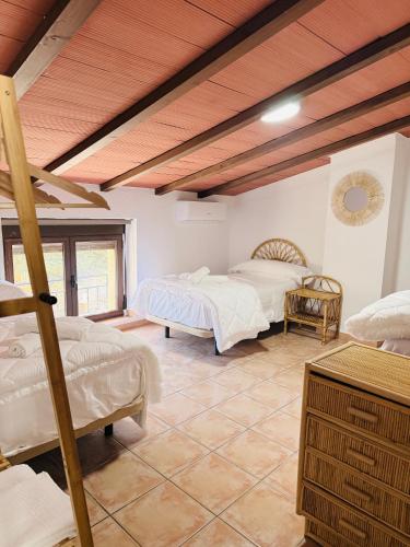 a bedroom with two beds and a wooden ceiling at Casa Luisa Archivel in Archivel