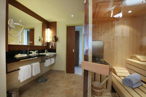 a bathroom with a sink and a mirror at Lindner Hotel Hamburg am Michel, part of JdV by Hyatt in Hamburg