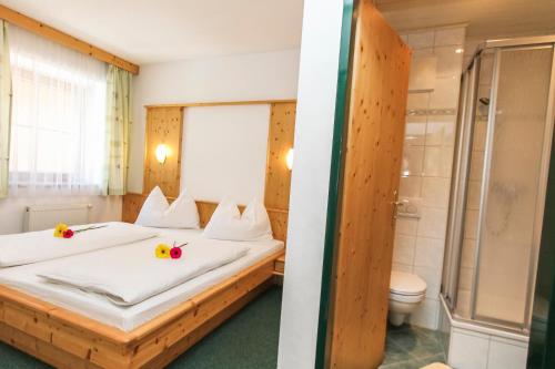 sypialnia z 2 łóżkami i prysznicem w obiekcie Appartements Trinker w mieście Zell am See