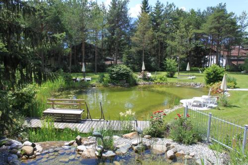 a pond in a garden with a picnic table and benches at Apart-Elisabeth in Mieming