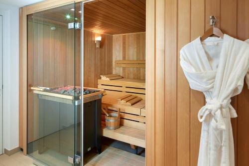 uma cabina de duche ao nível do chão com uma porta de vidro e uma toalha em Campus Hotel Hertenstein em Weggis