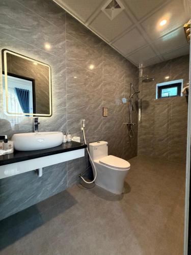 a bathroom with a toilet and a sink and a shower at Honeybee Villa in Văn Lâm