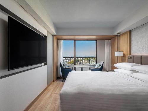 a hotel room with a bed and a flat screen tv at Hamamatsu Marriott Hotel in Hamamatsu