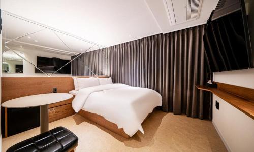 ein Schlafzimmer mit einem großen Bett und einem Tisch in der Unterkunft 신촌 어반슬로우 in Seoul