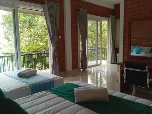 a bedroom with two beds and a balcony at Leon Hilltop Resort in Kitulgala