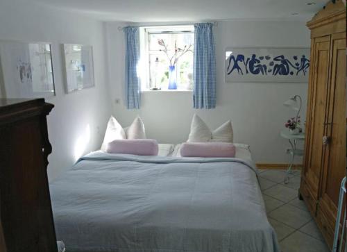 a bedroom with a bed with pink pillows and a window at Alte Boddenkate in Born