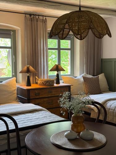 a bedroom with two beds and a table with flowers on it at Dom na Krzewiu in Gryfów Śląski