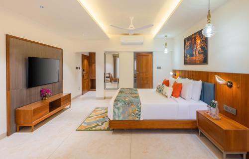 a bedroom with a bed and a flat screen tv at The Forest Chapter by Sayaji Madhai in Sohāgpur