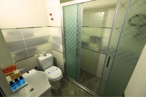 a bathroom with a toilet and a glass shower at Ephesus Nobel Otel in Selçuk