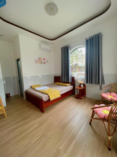 a bedroom with a bed and a large window at Happy Villa in Phú Hiệp