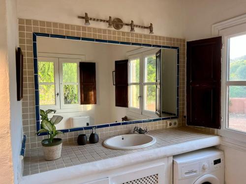 a bathroom with a sink and a large mirror at Balearic Sunset Apartment in Santa Gertrudis de Fruitera
