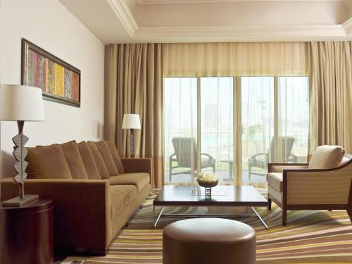 a living room with a couch and a table at Grand Hyatt Doha Hotel & Villas in Doha