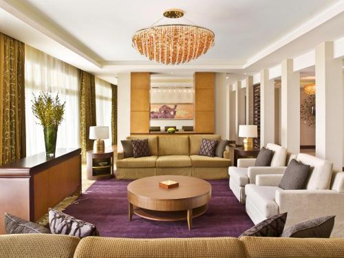 a living room with couches and a chandelier at Grand Hyatt Doha Hotel & Villas in Doha