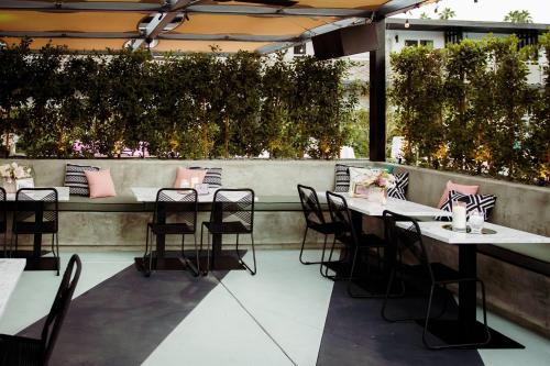 a row of tables and chairs on a patio at V Capri Palm Springs, a Dolce by Wyndham in Palm Springs