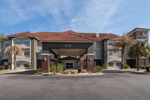a hotel building with palm trees in front of it at La Quinta by Wyndham Savannah Airport - Pooler in Savannah